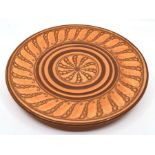 A Royal Doulton charger brown abstract decoration on an orange ground. Diameter approx 34cm. No