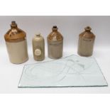 A collection of stone ware brewery bottles, a stoneware foot warmer along with an etched glass panel