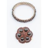 A Victorian garnet set gilt metal brooch, circular form set to the centre with  rose cut garnet with
