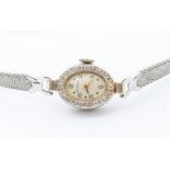 A ladies Wittnauer 14ct white gold and diamond set cocktail watch, comprising an oval cream dial