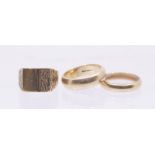 Three 9ct gold rings comprising two gold wedding bands, sizes P and R1/2, and a square topped signet