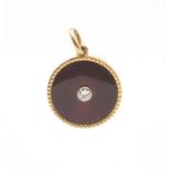 An enamel and diamond gold pendant, circular design collet set with a round old cut diamond,