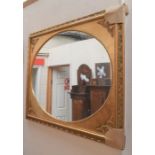 A Dutch mirror, in gilt, with oval mirror panel and ornate surround