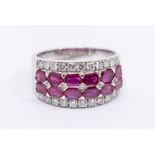 A ruby and diamond 18ct white gold dress ring, comprising a central double row of emerald cut rubies