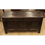 A late 17th Century oak coffer, the front section with three carved floral motif panels, on plain