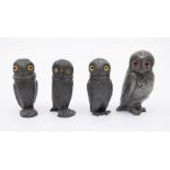 4 novelty pewter pepper pots modelled as owls, with glass eyes. Height of tallest approx 9cm.