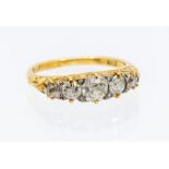 A diamond and 18ct gold five stone ring comprising brilliant cut diamonds, scrolled gallery,