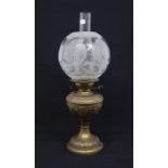 A late Victorian brass oil lamp with etched glass shade and funnel