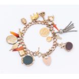 A 9ct rose gold charm bracelet including various 9ct gold and gilt metal charms including swivel