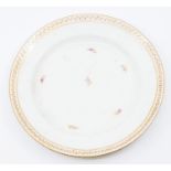 A Coalport circular plate, circa 1800, the border painted with a band of gilt leaves and berries,