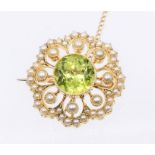 An Edwardian peridot and pearl set gold brooch, comprising a central round cut  peridot set to the