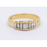 A diamond and 18ct gold eight stone ring, comprising channel set tapered baguette cuts set to the