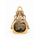 A 19th Century yellow metal swivel fob set with smoky quartz intaglio of various crest, Coats of