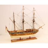 A wooden model ship, 'Royal Caroline', upon wooden stand. Measuring approx. 85cm length x 72cm