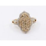 A diamond and 9ct gold cluster ring comprising a Arabic motif grain set with round brilliant cut
