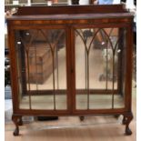 A mid 20th Century display cabinet in mahogany, having two glazed doors and two glass shelves