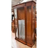 A contemporary glazed display cabinet having bevelled glass panels, central door and 5 internal