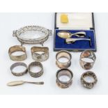 A collection of early 20th Century silver to include: four various napkin rings; a cased Child's