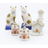 A collection of Staffordshire money boxes, ceramic houses, cream wares and early 20th Century cats