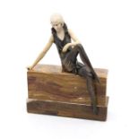 An Art Deco bronze and resin figure of a seated dancer, on marble plinth