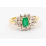 An emerald and diamond cluster 18ct gold ring, comprising an emerald cut emerald to the centre,