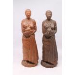 A pair of hand-crafted clay figures of nursing mothers, 40cm tall, slightly different hues, each