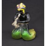 A circa 1960's glass figure of a man kneeling and playing horn to a cobra in basket