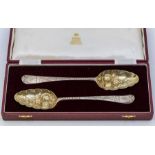A cased pair of George III silver gilt berry spoons by John Munns, London 1766, retailed by