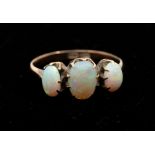 An opal and 9ct gold three stone ring, comprising three oval graduated opals, claw set in rose gold,