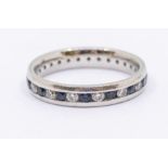 A sapphire and diamond platinum eternity ring, comprising alternate round cut sapphires and