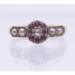 An early 20th century ruby, pearl and diamond 18ct gold ring, comprising a floral cluster set to the