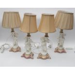 A set of four late 19th/early 20th Century porcelain table lamp bases, each modelled as a Putti with