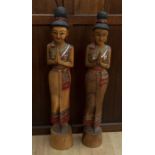 Two large Thai wooden figures of ladies greeting, with coloured glass detailing