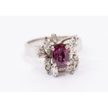A ruby and diamond 18ct white gold dress ring, comprising a central claw set oval ruby approx 5 x