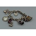 A silver charm bracelet (hallmarked) with eight charms, to include a gramophone with a turning