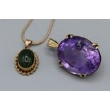 A pair of pendants, one an amethyst measuring 28mm x 21mm in a yellow metal mount assessed as