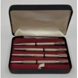 A set of four bridge scoring sterling silver pencils, each with different enamel card suit symbol to