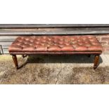 A leather buttoned window bench stool, leather worn