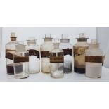 A collection of 13 Victorian hand blown apothecary jars with original stoppers and labels. Crack