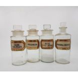 Circa 1900, 4 clear glass chemist jars, with original stoppers and original applied labels.