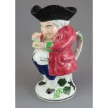 An early nineteenth century pearlware Scottish toby jug, c. 1830. It is decorated with colours in