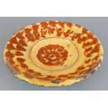 An early nineteenth century slipware dish, c. 1800. It is decorated with a geometric pattern.18 cm