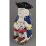 An early nineteenth century pearlware toby jug, c. 1830. It is decorated with a blue jacket and he