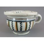 An eighteenth century tin glazed earthenware small chamber pot, c. 1760. It is decorated with a