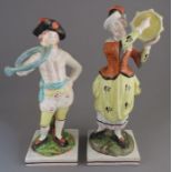 A pair of early nineteenth century pearlware Musician figures on square red line bases, c. 1820. The