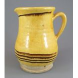 An early nineteenth century yellow glazed slip decorated jug with brown highlights, c. 1820. 16 cm