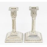 A pair of Victorian silver candlesticks, detachable drip pans, acanthus sconces above twisted column