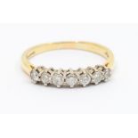 A diamond and 18ct gold eternity ring, comprising seven claw set round brilliant cut diamonds, total