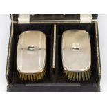 A matched pair of Modern silver mounted engine turned clothes brushes and comb, hallmarked by Barker