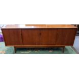 Teak mid century sideboard with 4 sliding doors and shelved interior.